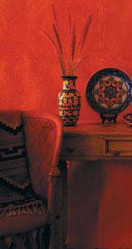 
A hand-painted ceramic vase and plate by El ­Salvadoran artist Marina Mena sits comfortably atop a pinewood credenza table made by Mexican artisan Daniel Lobo. The traditional leather and wood armchair by Rafael Gomez Salcedo and a sheep wool Zapotec rug made by the Ruiz Bazan family add an authentic taste of Old Mexico. (All items are available from Novica.com.)
